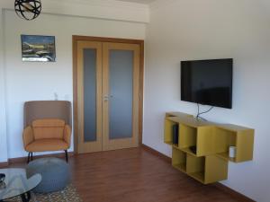 een woonkamer met een televisie en een stoel bij casalonne in Tavira