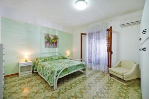a bedroom with a bed and a chair at Holiday flat, Castellammare del Golfo in Castellammare del Golfo