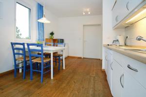 een keuken met een tafel en stoelen in een kamer bij Holiday homes Inselblick, Lohmen in Lohmen