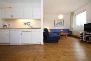 een keuken en een woonkamer met een bank en een tafel bij Holiday homes Inselblick, Lohmen in Lohmen