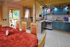 a kitchen and dining room with a table and chairs at Wooden House by Ostrowieckie Lake with Beach in Kosierzewo