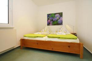 1 dormitorio con 1 cama con una pintura en la pared en Holiday homes Inselblick, Lohmen en Lohmen