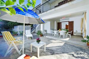 a patio with a table and chairs and an umbrella at Holiday flat, Castellammare del Golfo in Castellammare del Golfo