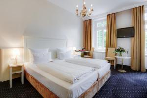 1 dormitorio con 1 cama blanca grande con lámpara de araña en Hotel Fürst Bismarck, en Hamburgo 37 fotos más