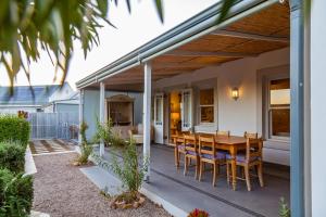 um pátio com uma mesa de madeira e cadeiras em Karoo Masterclass - Accommodation Prince Albert em Prince Albert