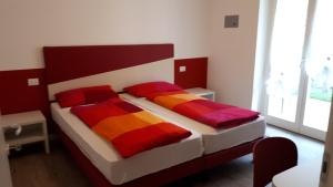 a bedroom with two beds with colorful pillows at appartamentsandreis in Malcesine