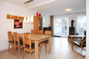 a dining room with a wooden table and chairs at Semi-detached house Rügentraum, Glowe in Glowe