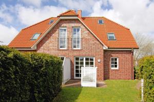 ein Backsteinhaus mit orangefarbenem Dach in der Unterkunft Ferienhaus Marlina Glückstreffer, Büsum in Büsum