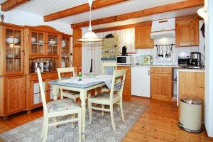 a kitchen with wooden cabinets and a table and chairs at Ferienhaus in Zempin mit Garten in Zempin +15 photos