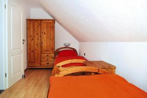 Cette chambre mansardée comprend 2 lits et une armoire. dans l'établissement Semi-detached house, Friedrichskoog-Spitze, à Friedrichskoog-Spitz