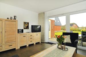 a living room with a tv and a couch and a table at Semi-detached house, Friedrichskoog-Spitze in Friedrichskoog-Spitze