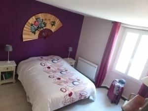 a bedroom with a bed with a flower decoration on the wall at Maison Berrichonne 2 chambres cour et jardin in Saint-Marcel
