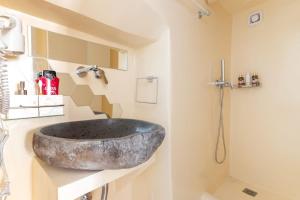 een badkamer met een grote stenen wastafel op een aanrecht bij aníko suites Chora in Mykonos-stad