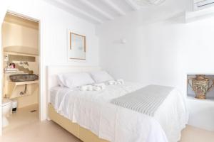 biała sypialnia z łóżkiem i łazienką w obiekcie aníko suites Chora w mieście Mykonos +21 zdjęć