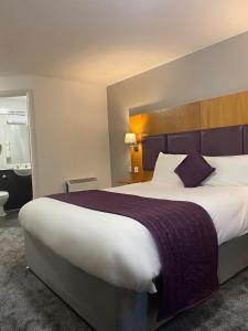 um quarto de hotel com uma cama grande e uma casa de banho em Purple Roomz Preston South em Preston