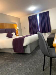 a hotel room with two beds and a television at Purple Roomz Preston South in Preston