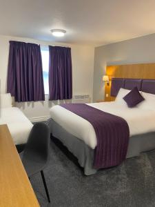 A bed or beds in a room at Purple Roomz Preston South