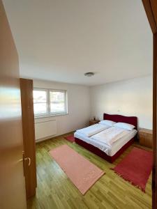 1 dormitorio con 1 cama y 2 alfombras rojas en Kuća Vesna en Kupres