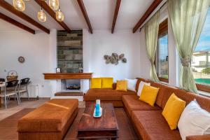 salon z kanapą i kominkiem w obiekcie Evilion Villa w mieście Jenadi
