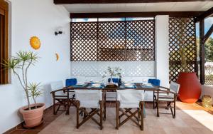 jadalnia ze stołem i krzesłami w obiekcie Evilion Villa w mieście Jenadi