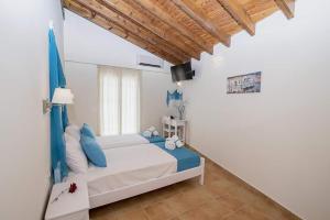 1 dormitorio con 1 cama con almohadas azules en Filoxenia Kirki Apartments by CorfuEscapes en Benitses