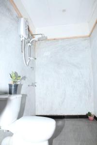 een badkamer met een wit toilet in een kamer bij Ella Relax Inn in Ella