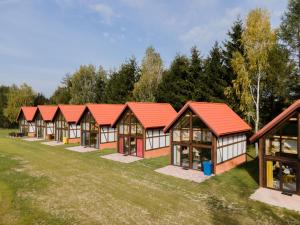 uma fila de casas com telhados vermelhos num campo em Nowe domy na Mazurach- Totutaj Wejsuny em Pisz