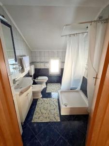 y baño con 2 aseos, lavamanos y bañera. en Kuća Vesna, en Kupres