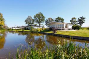 ein Haus mit einem Fluss davor in der Unterkunft TopParken – Park Westerkogge in Berkhout