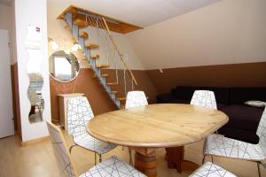 a dining room with a table and chairs and a spiral staircase at Vacation home, Neukirchen in Neukirchen