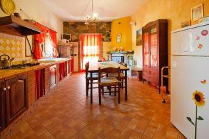 a kitchen with a table and a white refrigerator at Holiday home, Francavilla di Sicilia in Francavilla di Sicilia
