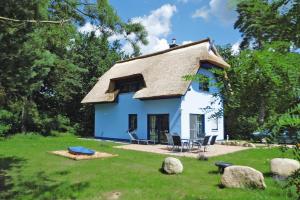 Casa azul y blanca con techo de paja en Holiday home my anchorage, Zirchow, en Zirchow