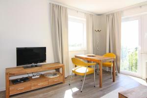 sala de estar con mesa y TV en Apartment, St Peter-Ording, en Sankt Peter-Ording