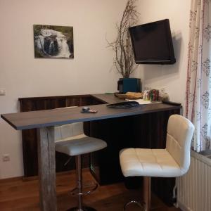 una scrivania in una camera con due sedie e una televisione di Biohof Köck Tonibauer a Zeutschach