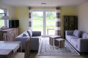 a living room with two couches and a table at Doppelhaushälfte Breetzer Boddentraum im Hafendorf Vieregge in Vieregge