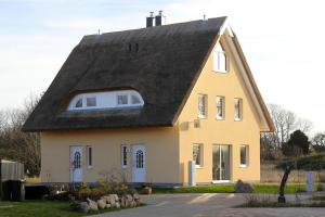 a yellow house with a black roof at Doppelhaushälfte Breetzer Boddentraum im Hafendorf Vieregge in Vieregge