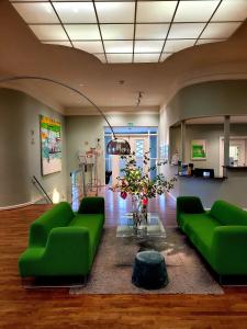 a living room with green couches and a table at Hotell Jeløy Radio in Moss