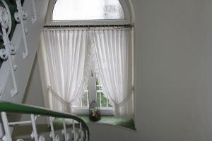 eine Treppe mit einem Fenster mit weißen Vorhängen in der Unterkunft Hotel Kurpfalzstuben in Mannheim