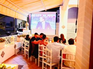 un gruppo di persone sedute a un tavolo a guardare una presentazione di Albergo 2 Mari a Leuca