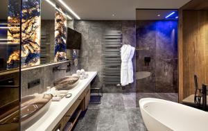 a bathroom with two sinks and a bath tub at Wellness- & Sporthotel Jagdhof in Röhrnbach