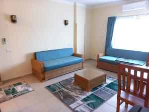una sala de estar con 2 sofás azules y una ventana en Embrace Guest House, en Luxor