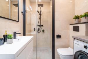 a bathroom with a shower and a toilet and a sink at Park View Apartment przy plaży in Iława