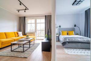 salon z łóżkiem i żółtą kanapą w obiekcie Park View - przy plaży, parking, TV55" z Netflix i Max w Iławie