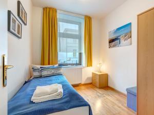 a bedroom with a blue bed and a window at Haus Meerblick - 04 in Ahlbeck