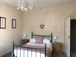 a bedroom with a bed and a chandelier at Valley Cottage in Keighley