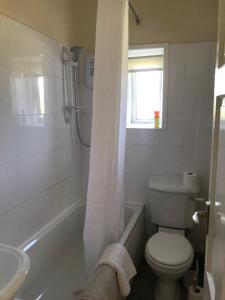 a white bathroom with a toilet and a sink at Valley Cottage in Keighley