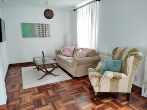- un salon avec un canapé et deux chaises dans l'établissement Apartamento Lurra Barrika, à Barrika