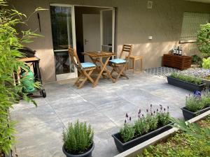 a patio with chairs and a table and some plants at Furnished studio with garden Seefeld I Tiefenbrunnen in Zurich