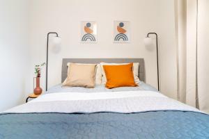 um quarto com uma cama azul com almofadas laranja em Central Apartment em Iława