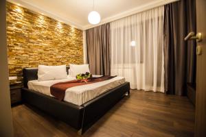 um quarto com uma cama e uma parede de tijolos em Business Class Apartment em Cluj-Napoca